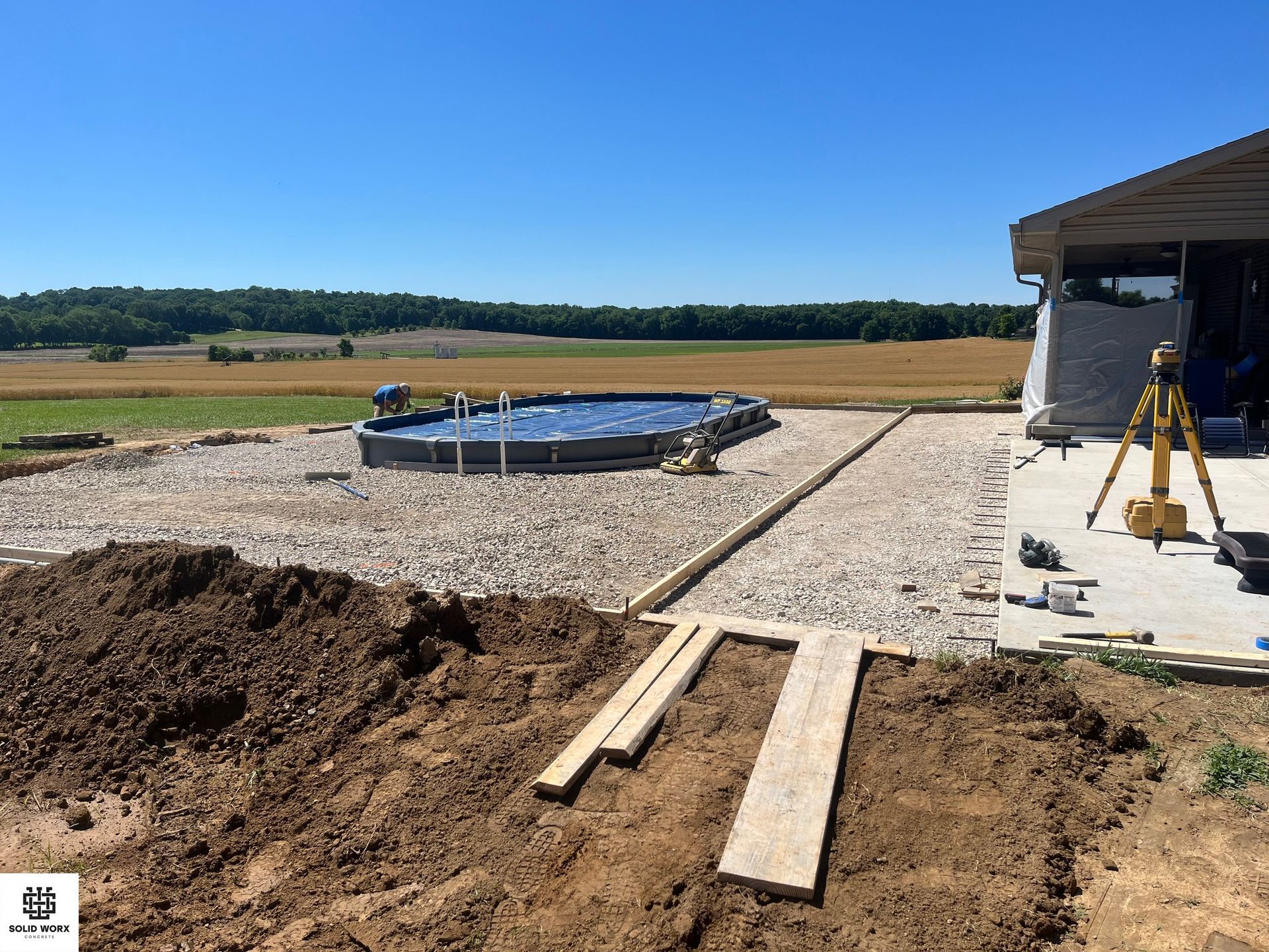 A swimming pool is being built in the backyard of a house.