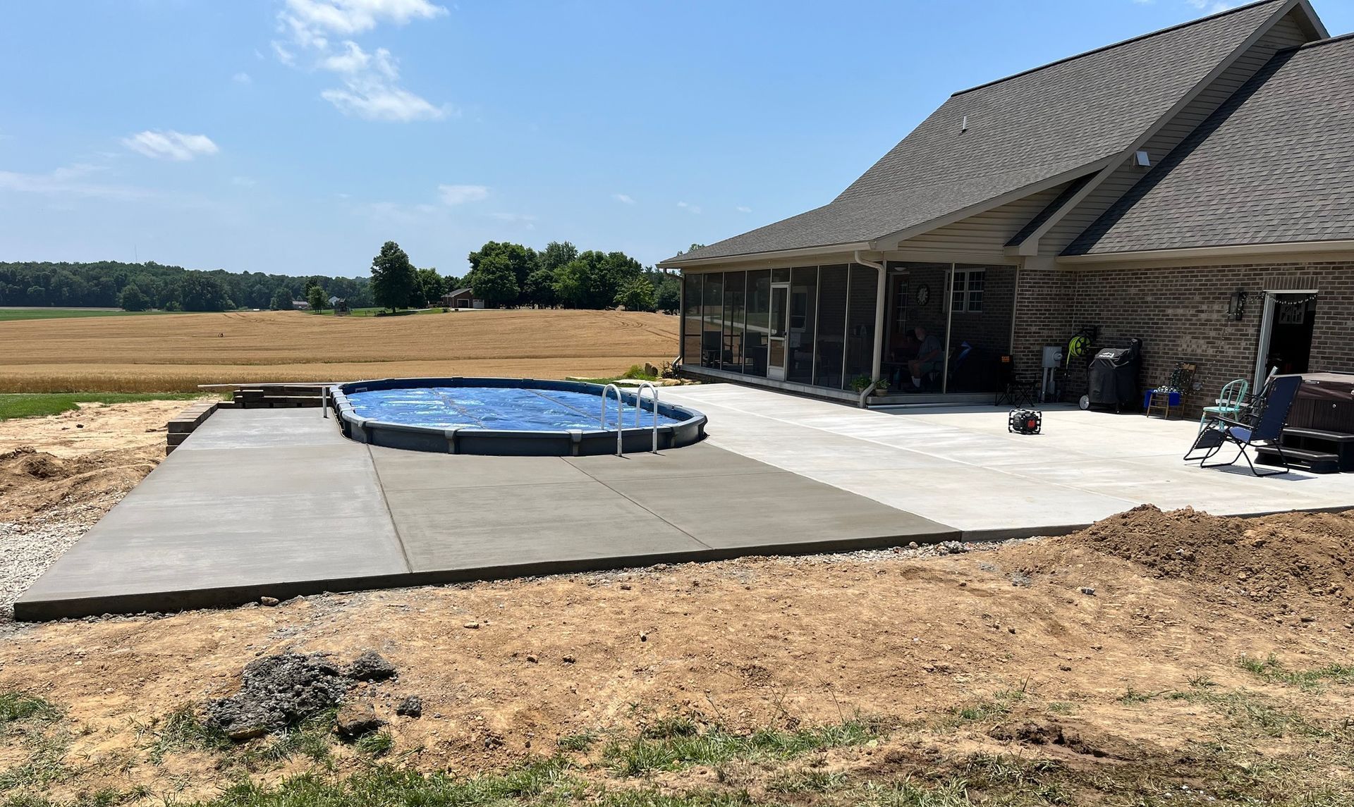 A large swimming pool is in the backyard of a house.