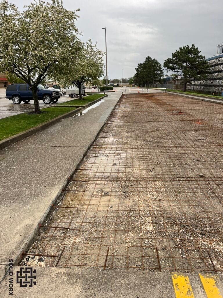 A concrete walkway is being built next to a parking lot.