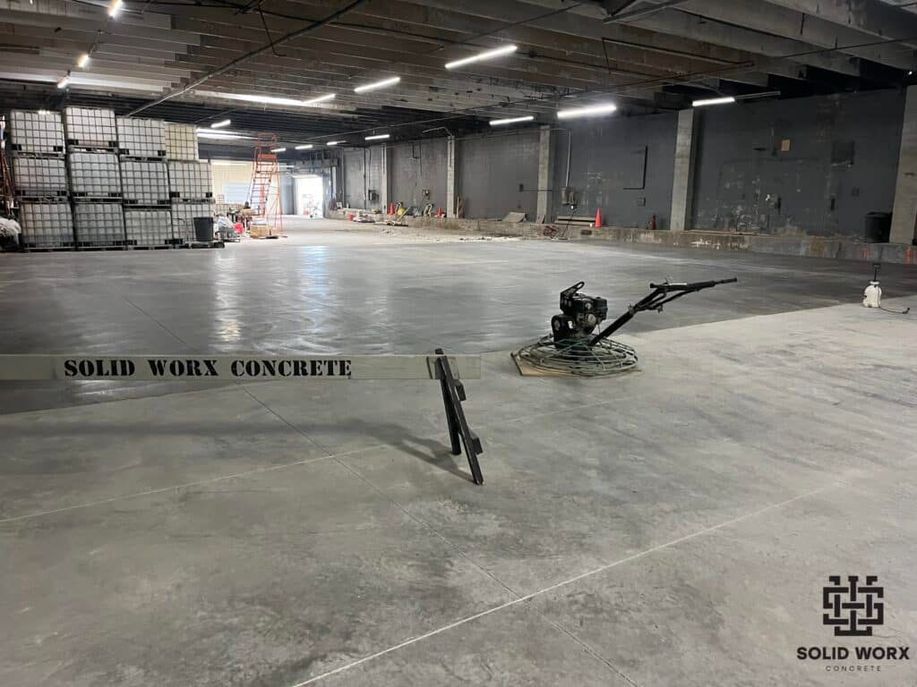 A large warehouse with a concrete floor and a machine on it.
