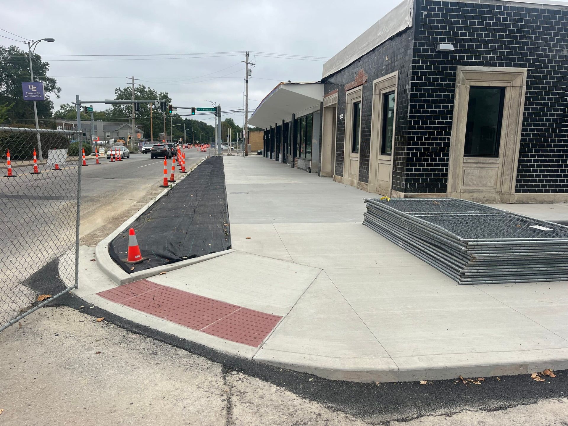 A sidewalk is being built in front of a brick building.