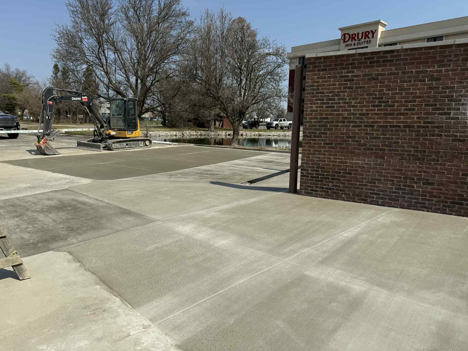 A concrete driveway is being built in front of a brick building.
