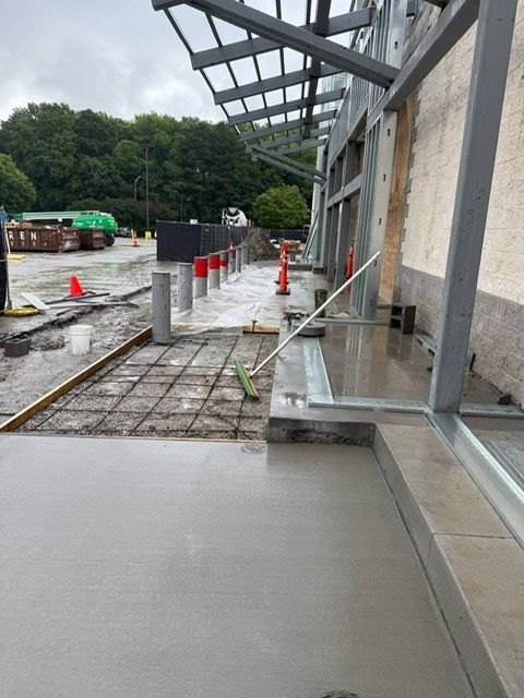 A concrete walkway is being built in front of a building