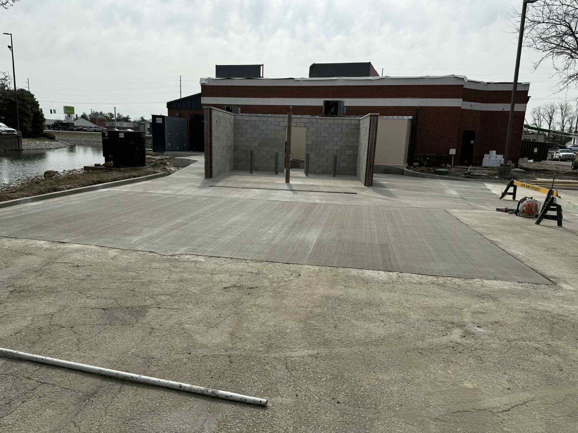 A car wash is being built in front of a brick building.