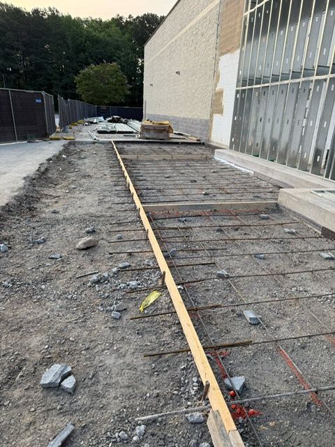 A concrete walkway is being built in front of a building.