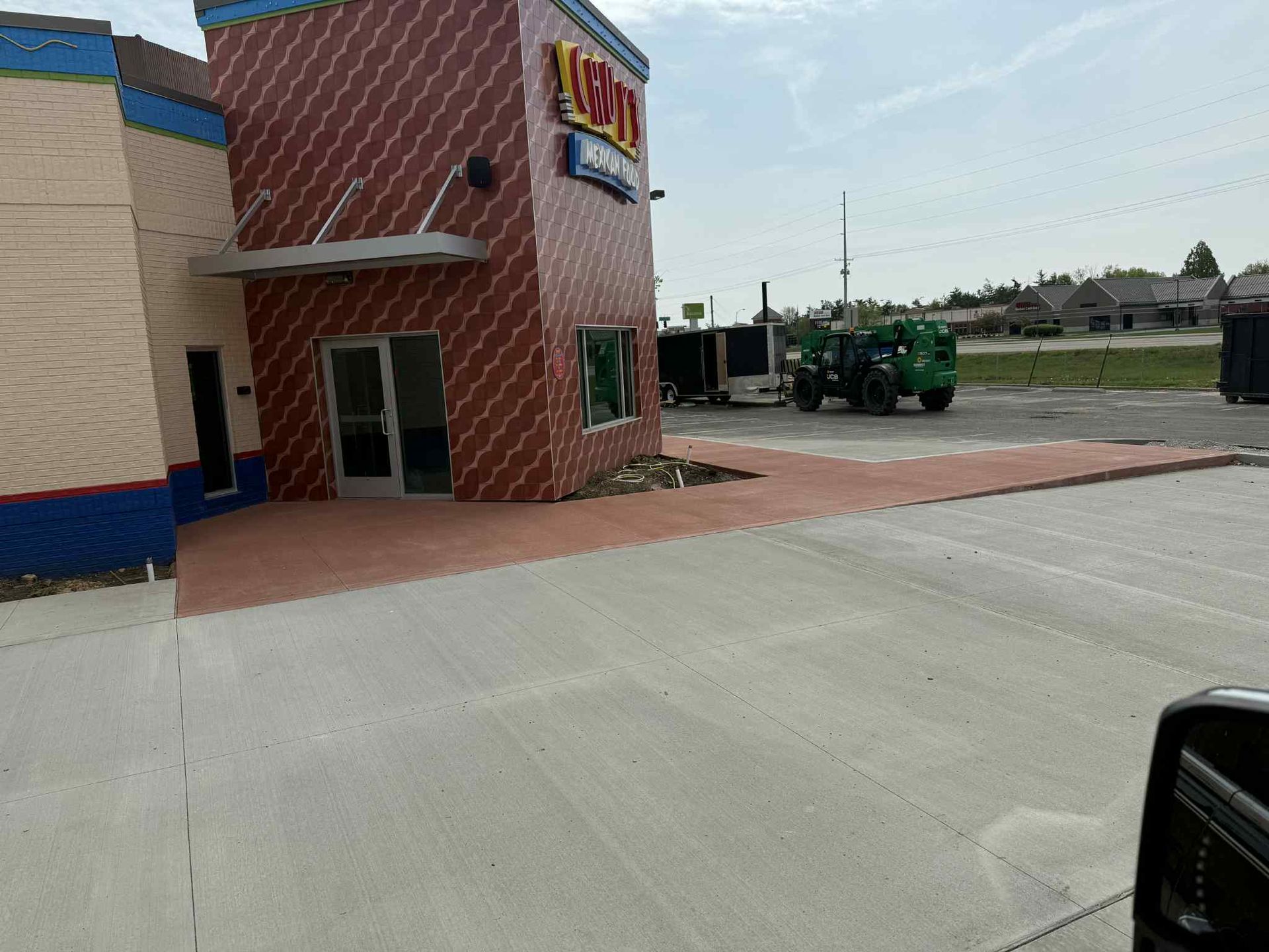 A brick building with a green truck parked in front of it.
