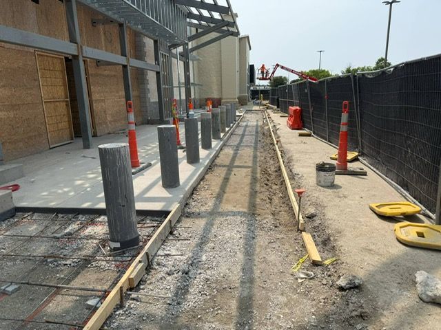 A concrete walkway is being built in front of a building