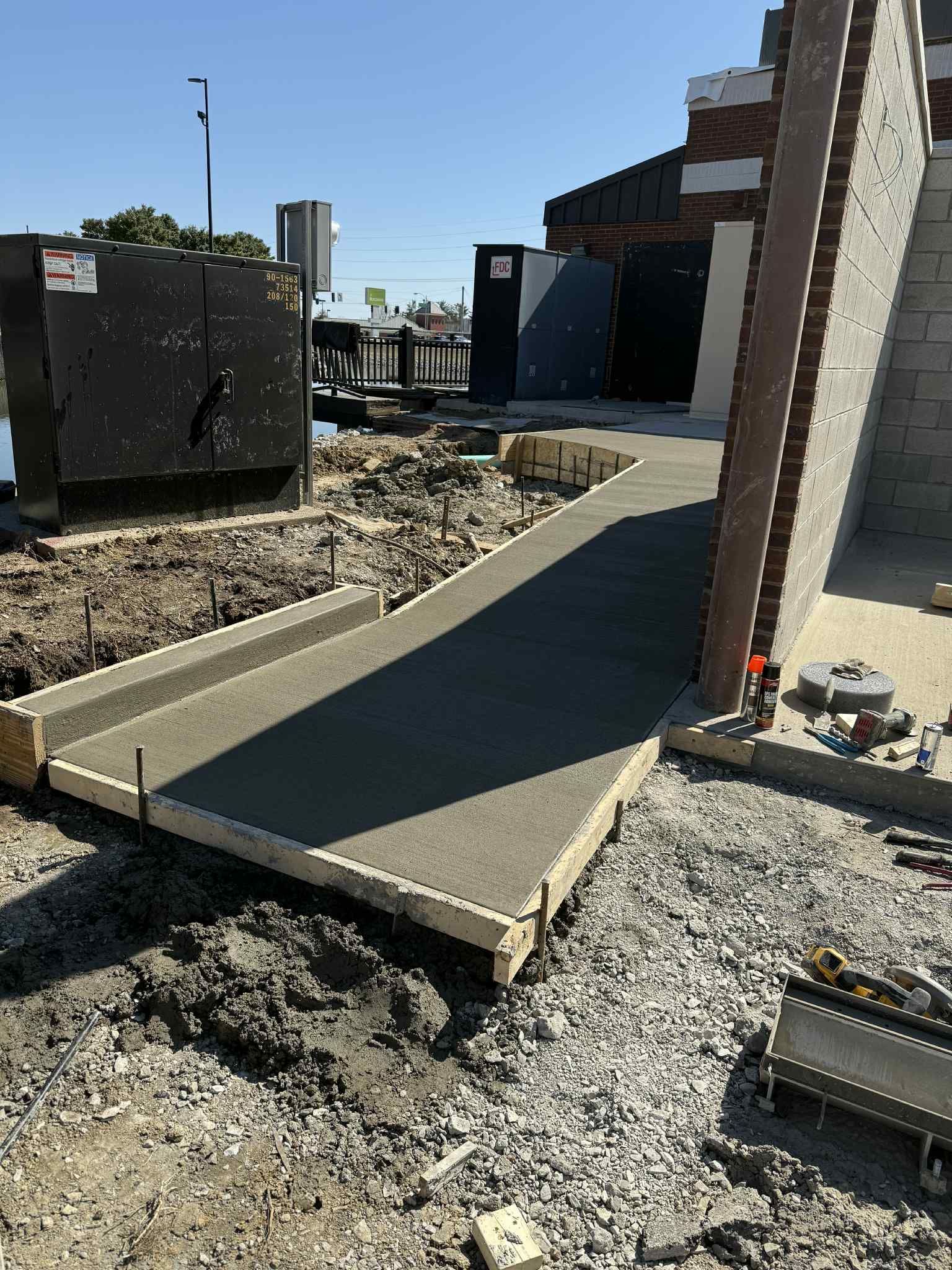 A concrete walkway is being built in front of a building.