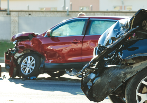 A red car and a black car are damaged in a car accident.