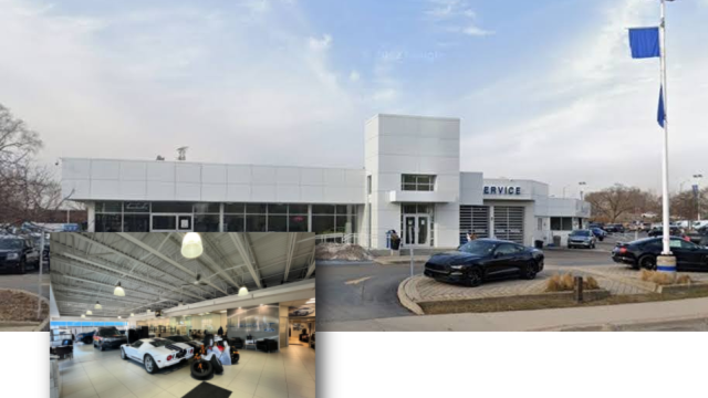 A picture of a car dealership with cars parked in front of it