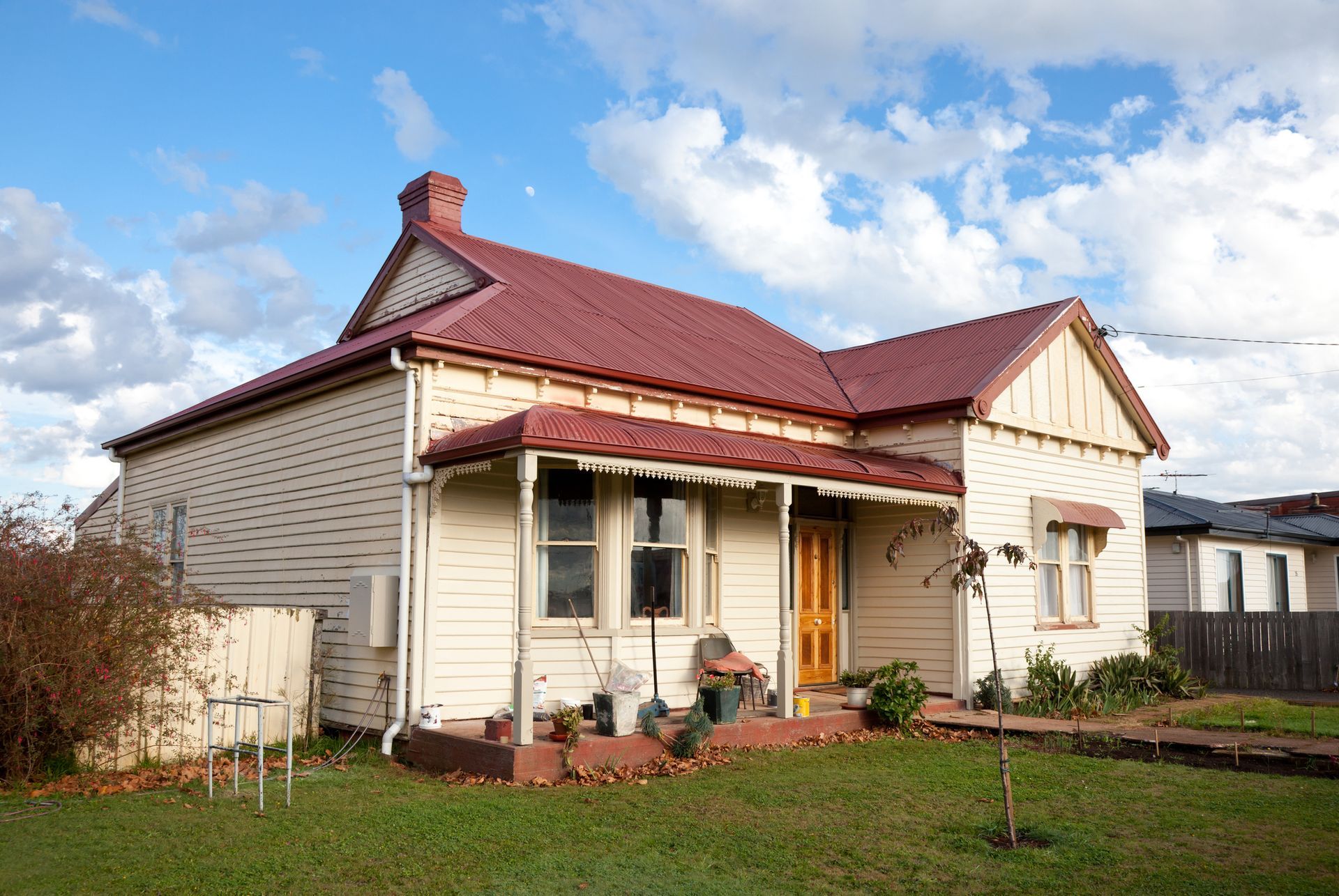 A white house with a red roof and a porch