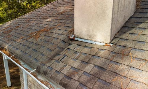 A roof with a chimney on top of it and a gutter.