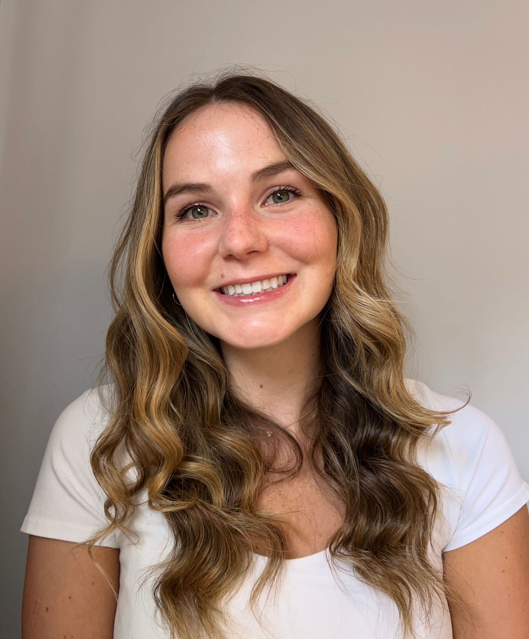 Emma Bannister headshot sitting on white chair