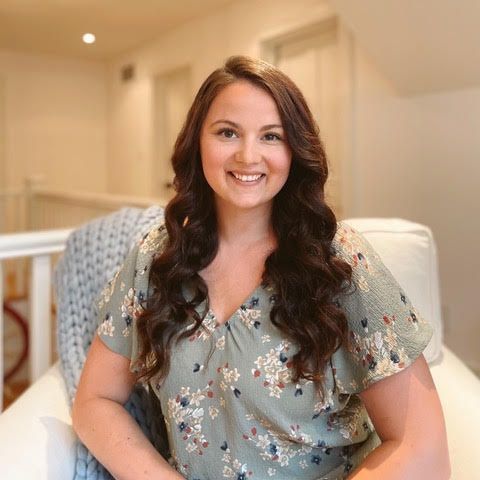 Emma Bannister headshot sitting on white chair
