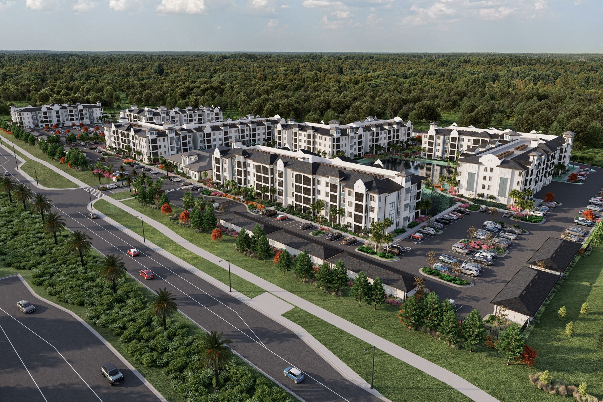 Aerial view of a multi-building apartment complex with parking, next to a road and treeline.