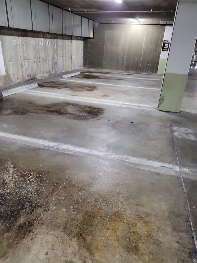 A dirty parking garage with a lot of dirt on the floor.