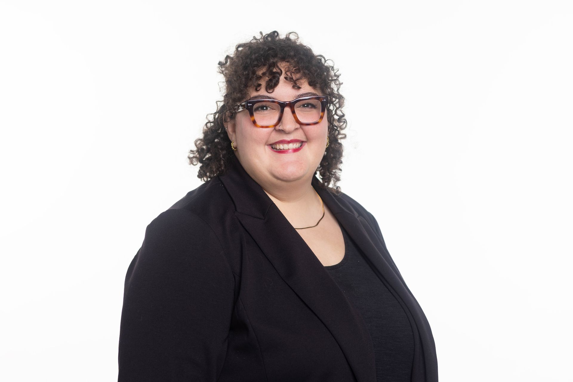 A man in a blue jacket and plaid shirt is smiling for the camera.