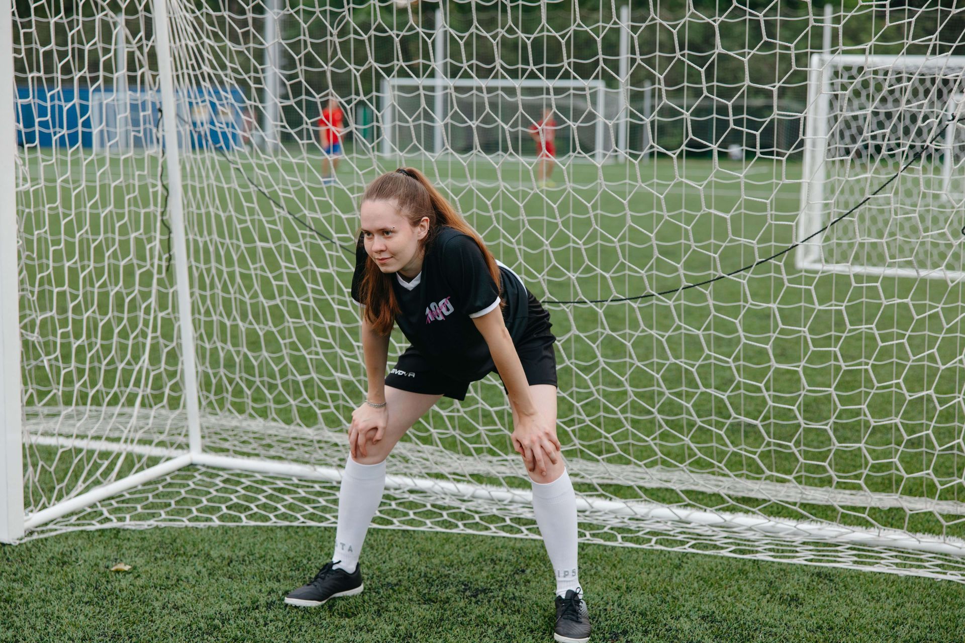 Woman goalie standing in front of a soccer net looking anxious, illustrating pressure and self-doubt addressed through anxiety and perfectionism therapy in Omaha, NE | anxiety and perfectionism therapy omaha ne - anxiety therapy omaha ne - anxiety therapist omaha ne - elkhorn - gretna - bennington - blair - millard - wahoo - waverly - papillion