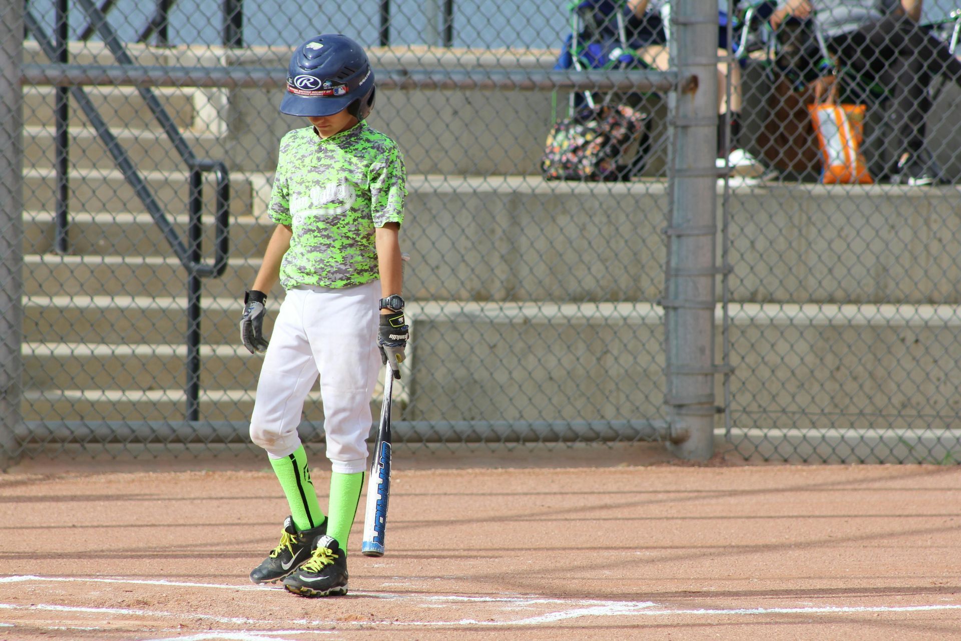 A young boy is standing on a baseball field holding a bat.