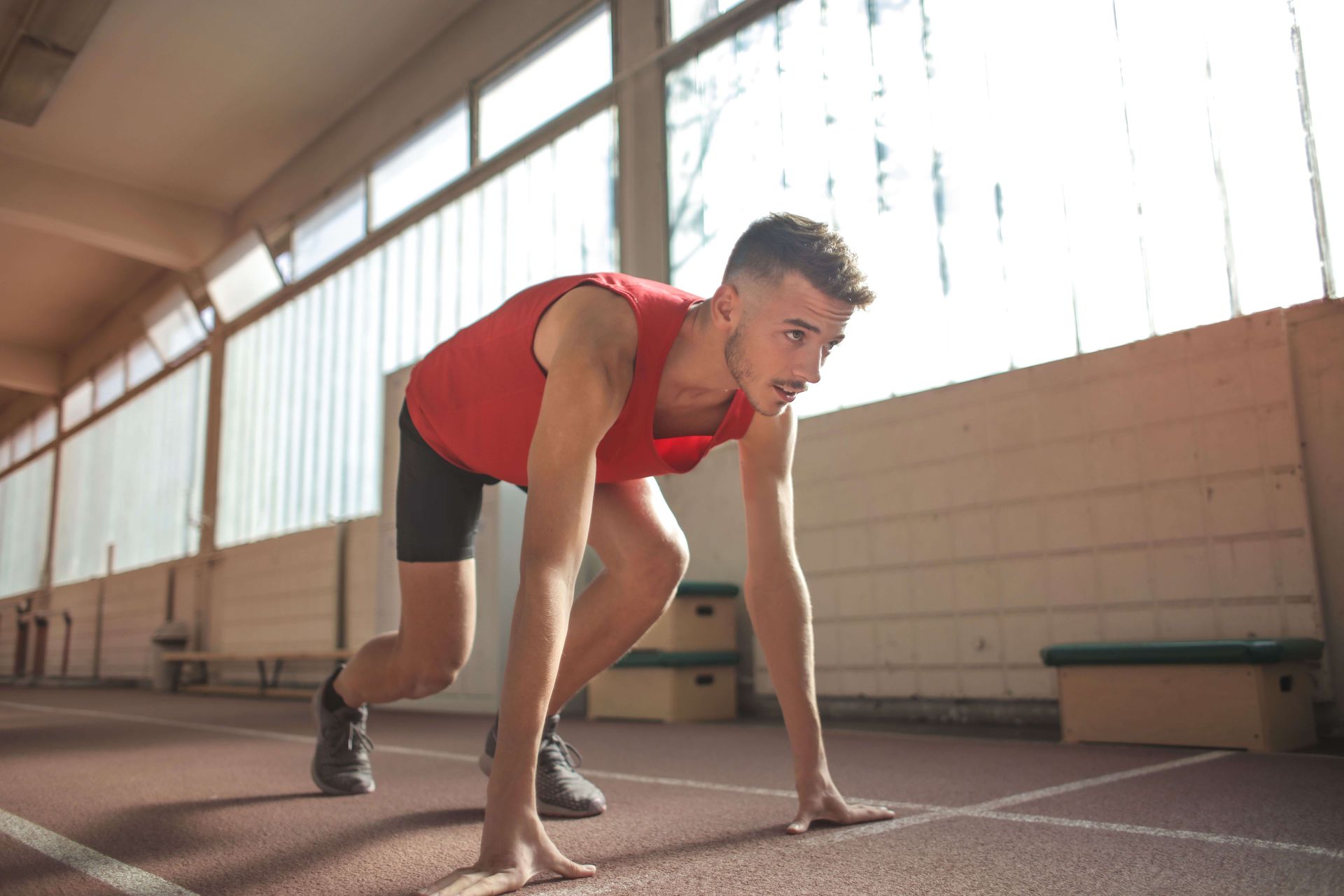 Man in a runner’s starting position looking focused, symbolizing resilience, confidence, and healthier performance patterns supported through anxiety and perfectionism therapy in Omaha, NE | anxiety and perfectionism therapy omaha ne - anxiety therapy omaha ne - anxiety therapist omaha ne - elkhorn - gretna - bennington - blair - millard - wahoo - waverly - papillion