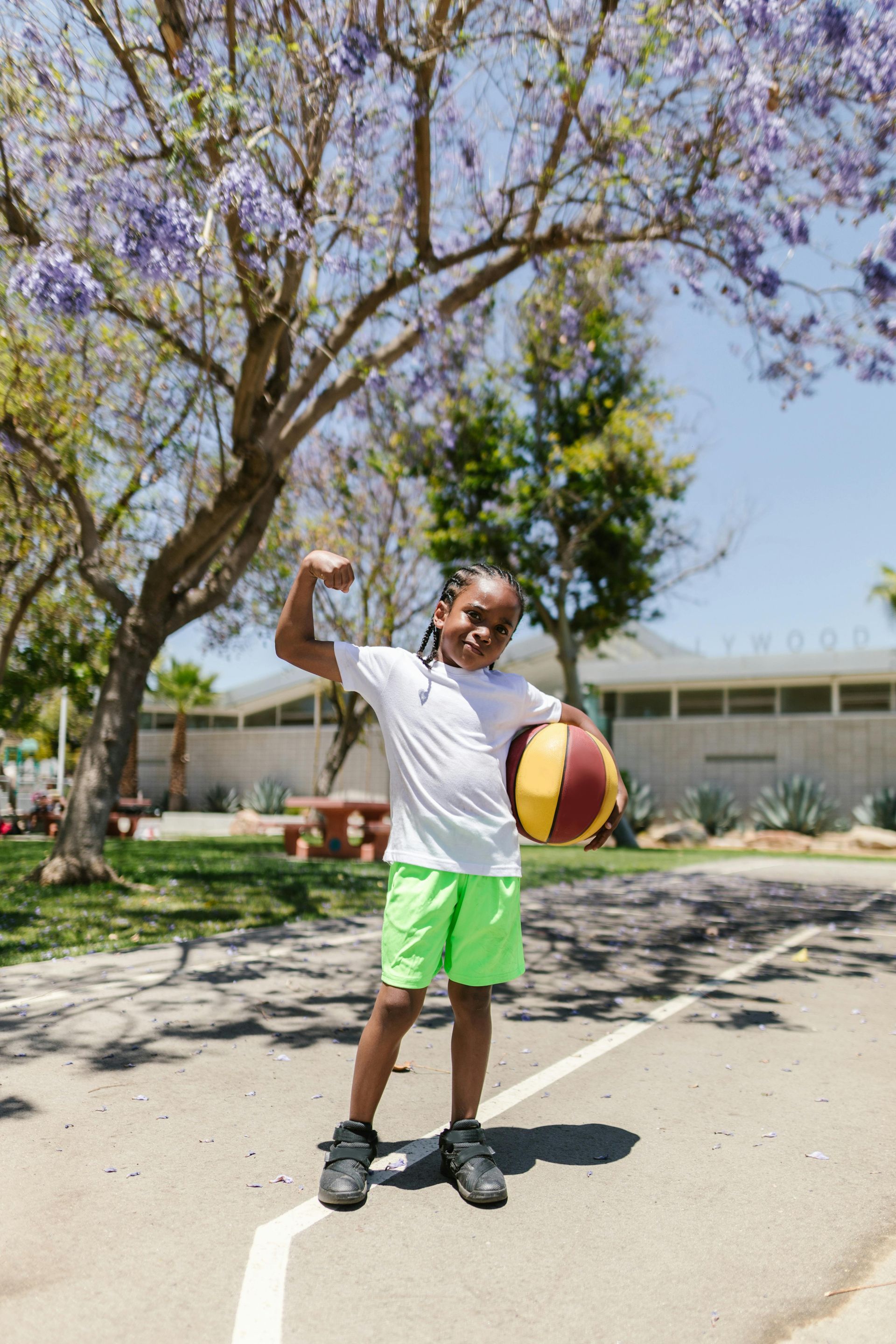 A young boy is standing on a basketball court holding a basketball.