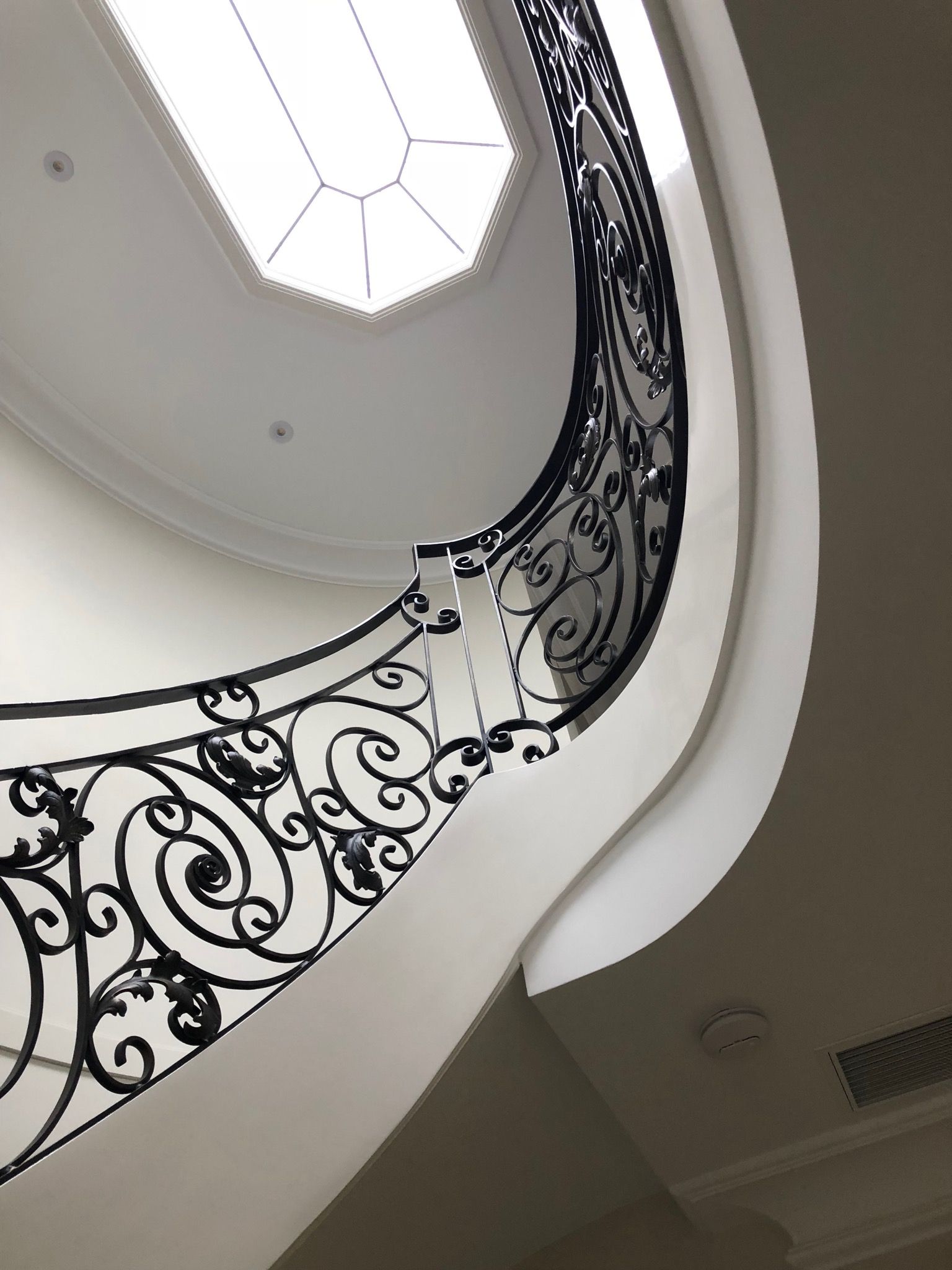 Looking up at a spiral staircase with a wrought iron railing