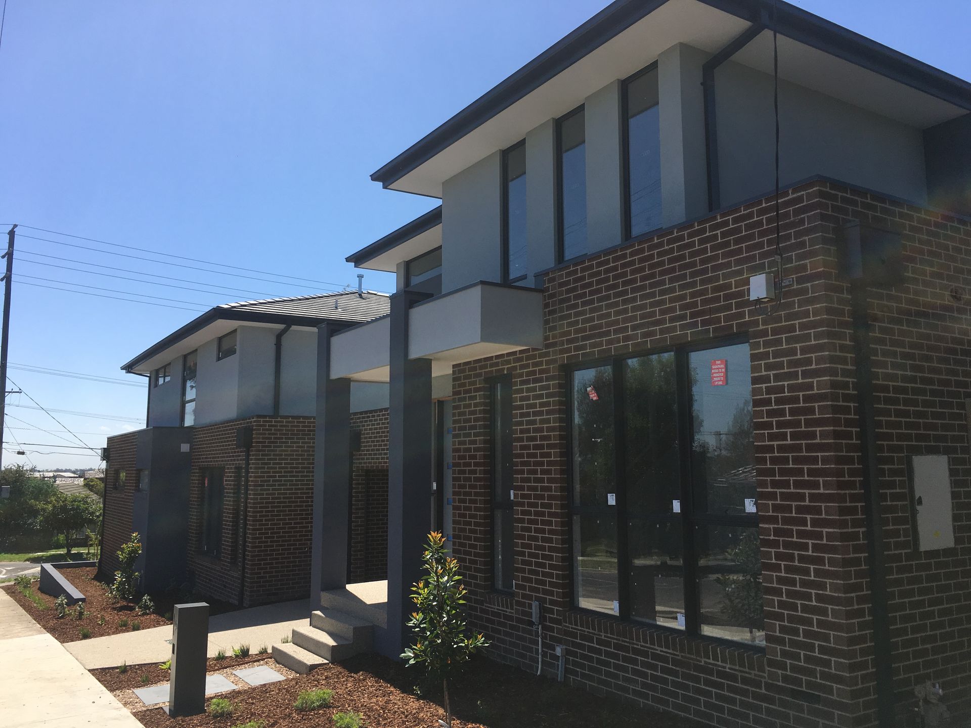 A row of brick houses with a blue sky in the background