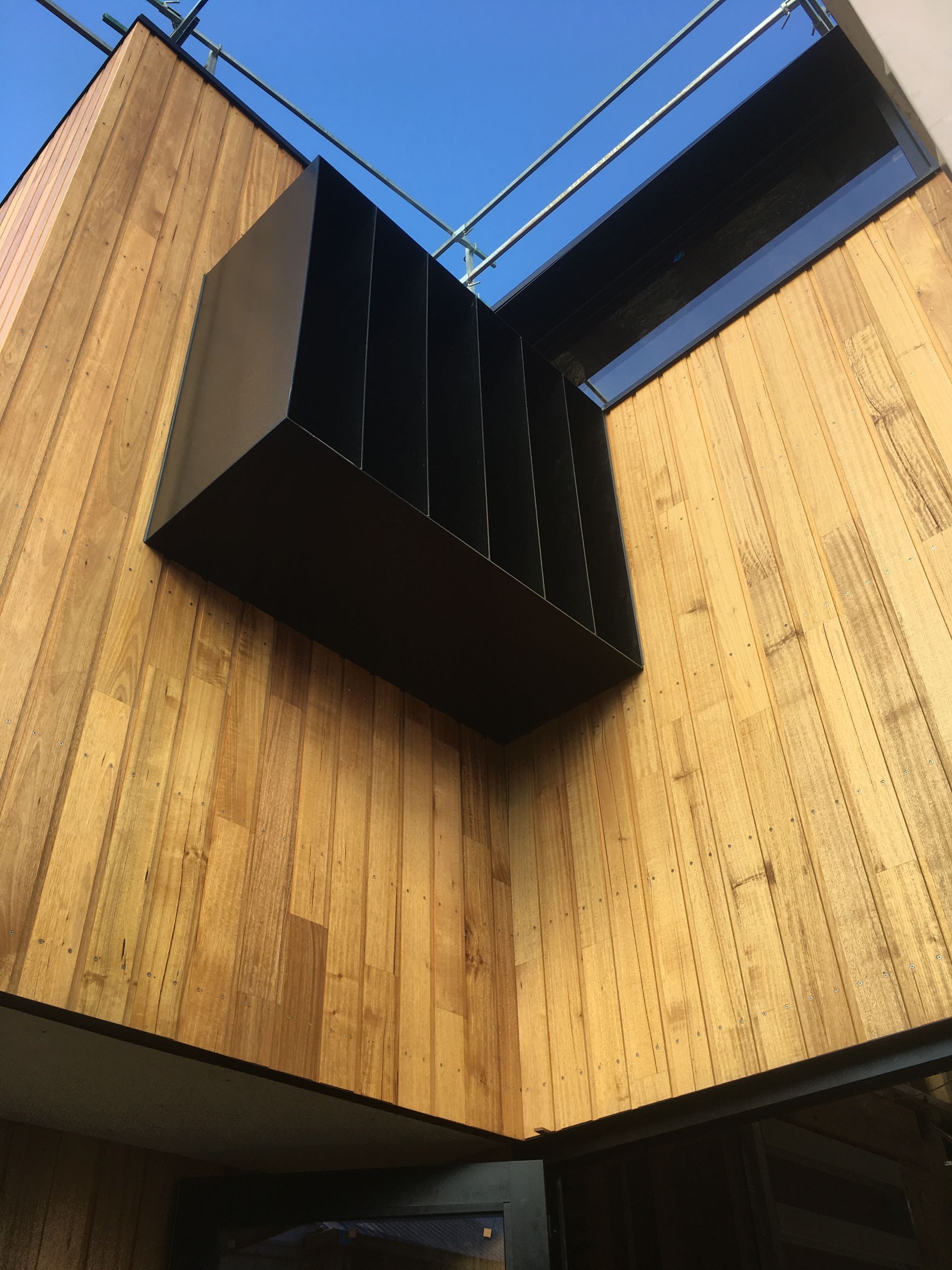 A wooden building with a black box on the side