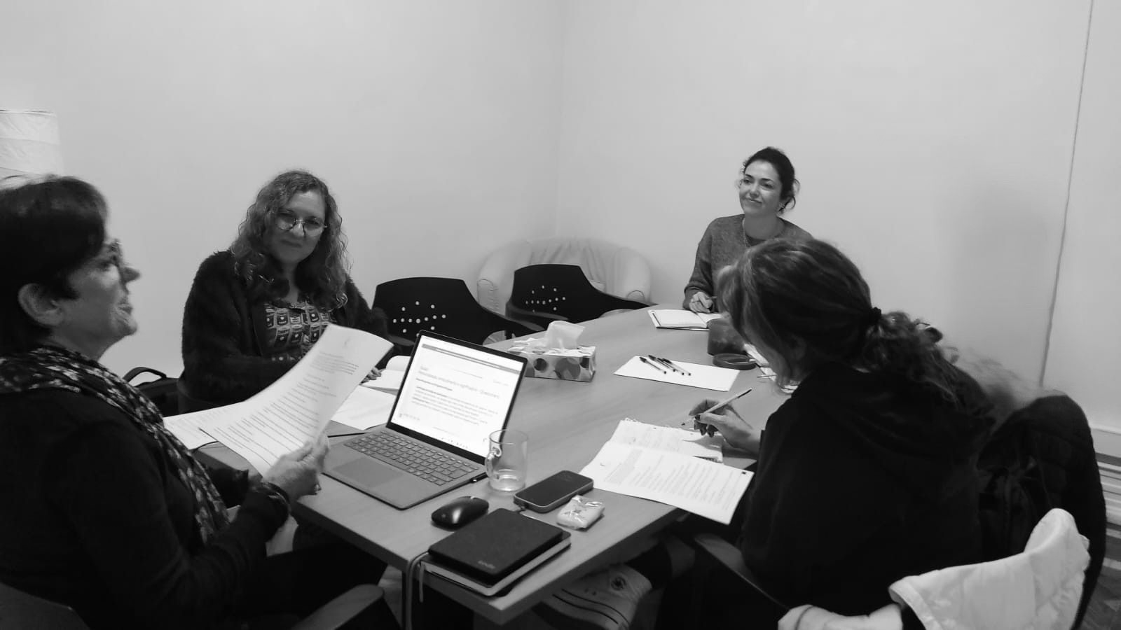 Sessão de formação presencial de celebrantes com participantes a analisar guiões de cerimónia e a tomar notas durante o curso de celebrantes.