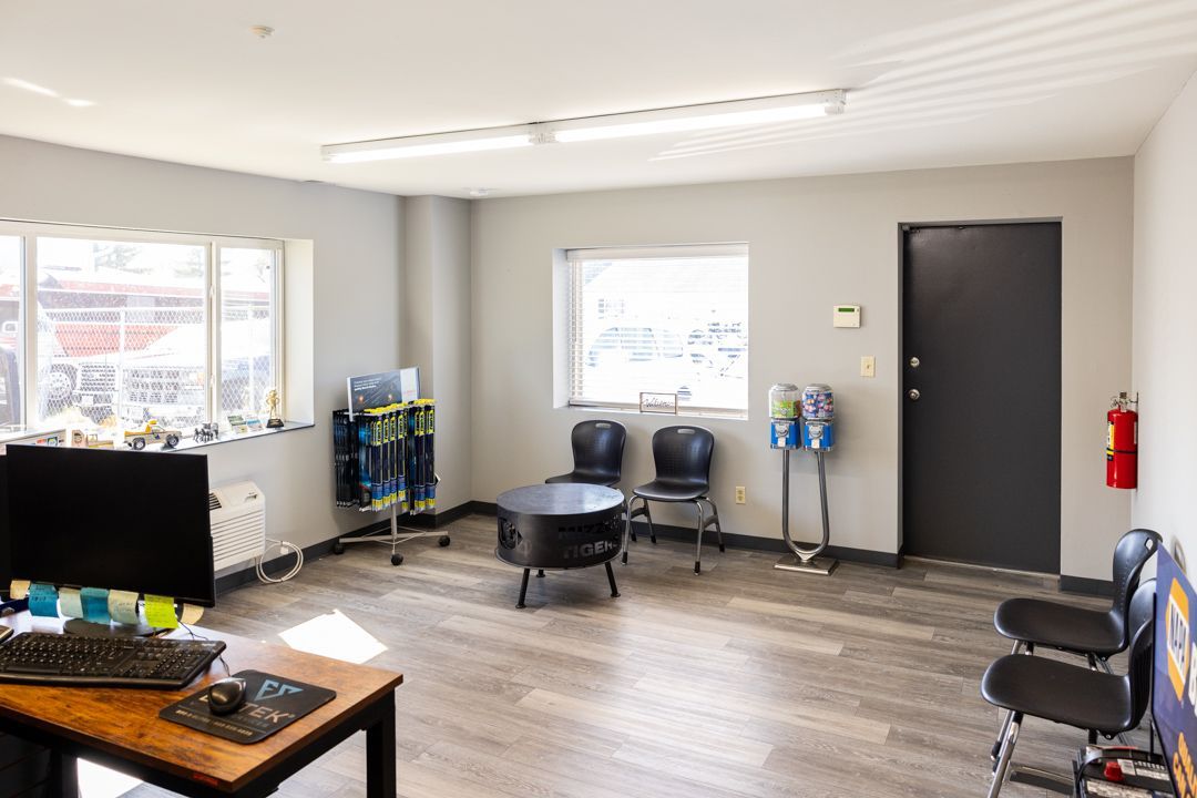 Waiting room with seating, a small fireplace, and a desk with a computer.