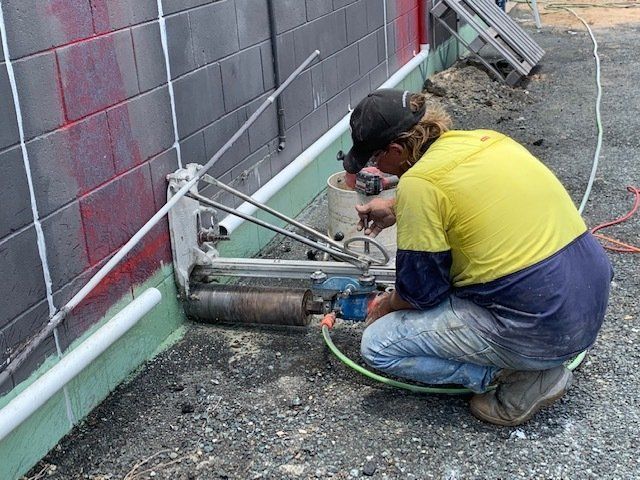 Worker Using Concrete Core Drilling Machine — Concrete Cutting In West Mackay, QLD