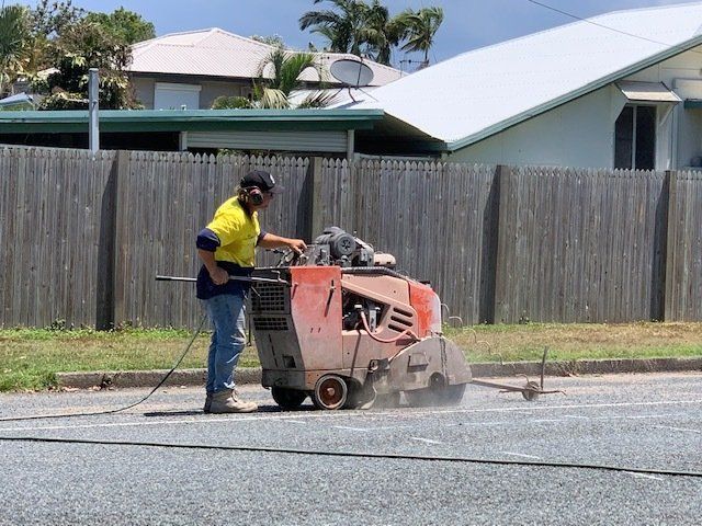 Worker Cutting Concrete Road — Concrete Cutting In West Mackay, QLD