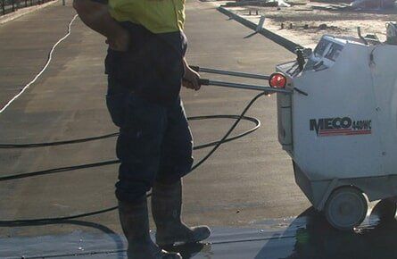 Tradie Using Machine New Concrete Floor — Concrete Cutting In West Mackay, QLD