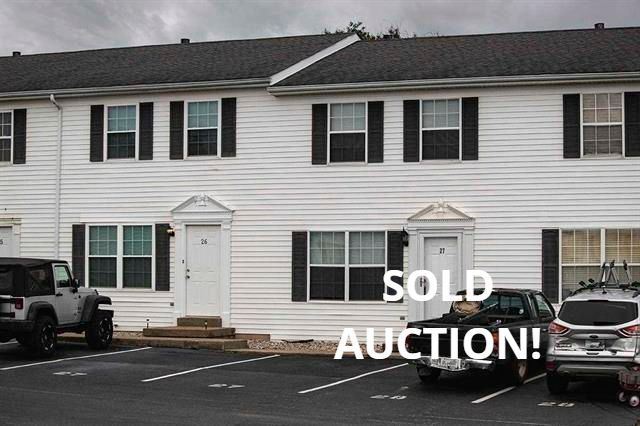 Row of white townhouses with black shutters.