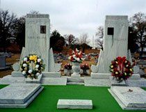There are two graves in the cemetery with flowers on them.