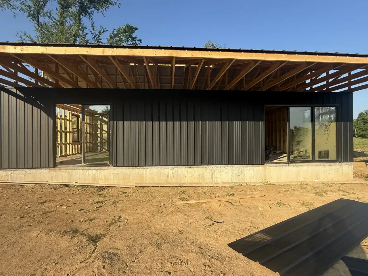 A house with a wooden deck and stairs with a sunset in the background.
