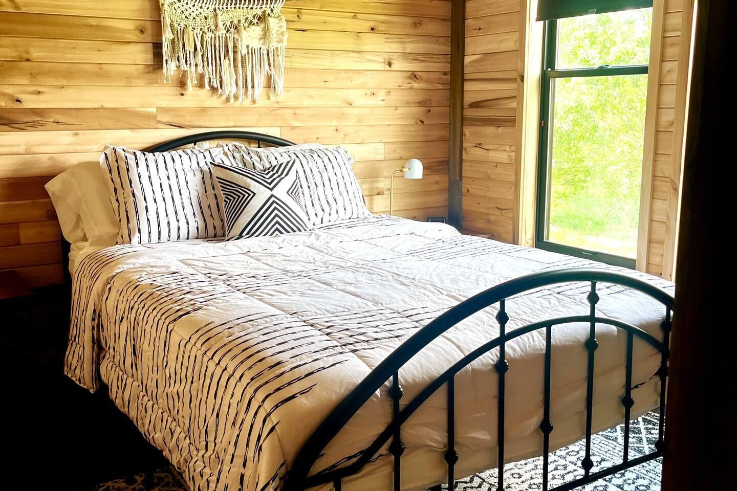 A bedroom with a king size bed and a window.