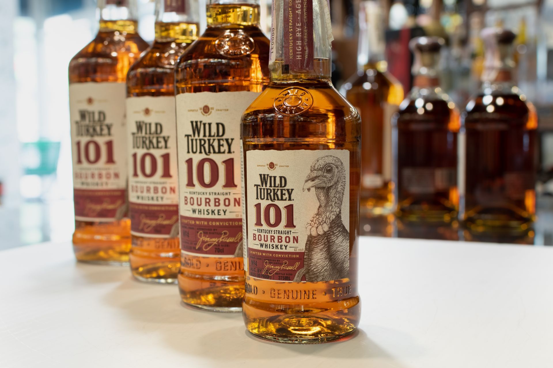A row of bottles of wild turkey 101 bourbon on a table.
