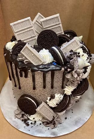 A cake with oreos and hershey bars on top of it.