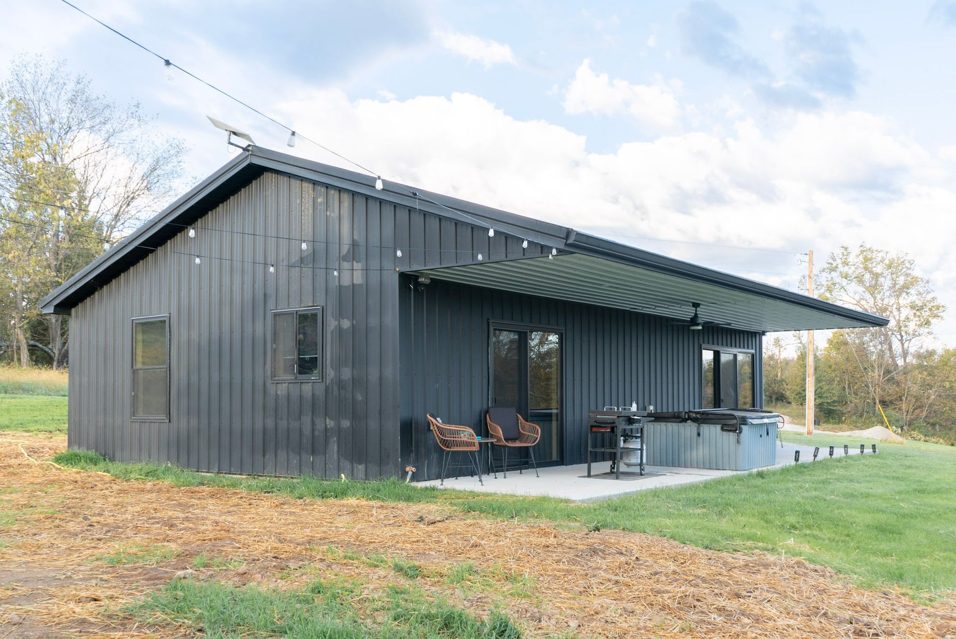 A house with a wooden deck and stairs with a sunset in the background.