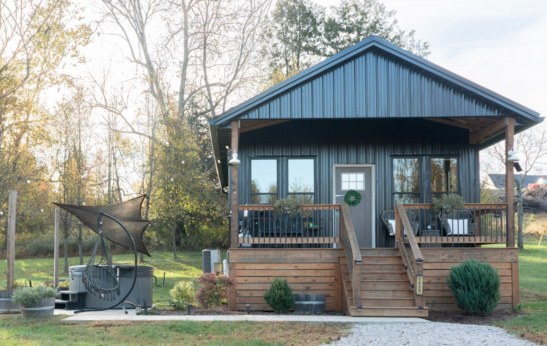 There is a fire pit in the middle of the yard with chairs around it.