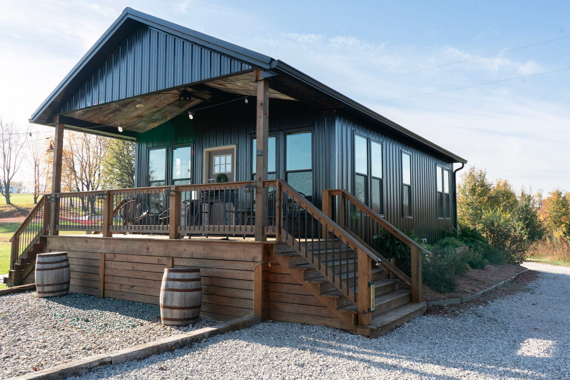 A house with a wooden deck and stairs with a sunset in the background.
