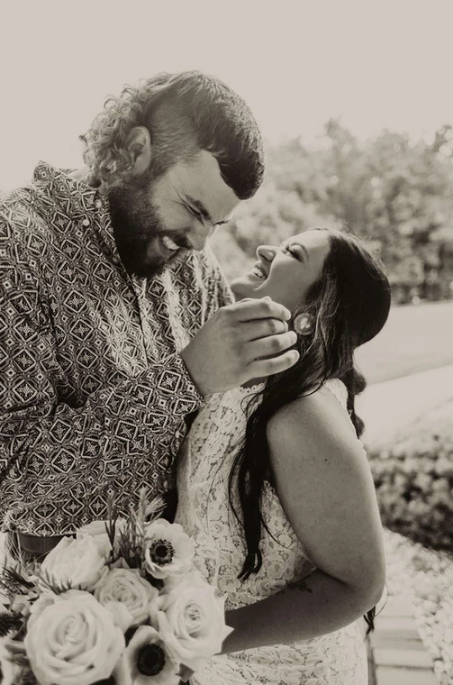 A bride and groom are kissing in a black and white photo.