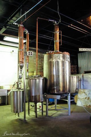 A large stainless steel distillery is sitting in a room.
