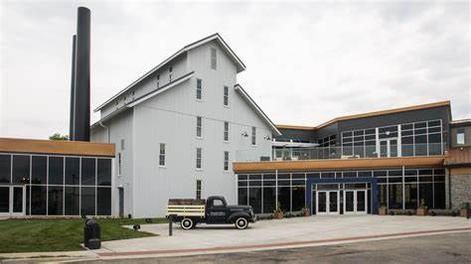 A black truck is parked in front of a large building