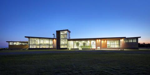 A large building with a lot of windows is lit up at night.