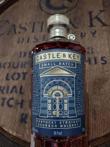 A bottle of kentucky straight bourbon whiskey is sitting on top of a wooden barrel.