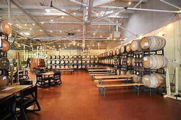 A large room filled with lots of barrels and tables.
