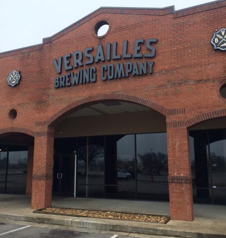 A brick building with a sign that says versailles brewing company