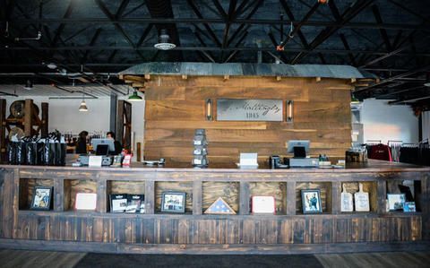 A large wooden counter in a restaurant with a wooden wall behind it.